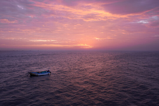 Small boat sailing in the Pacific Ocean near Pimentel Pier in Chiclayo during a beautiful sunset.