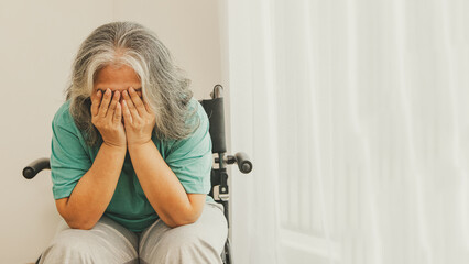 Asian elderly woman in wheelchair sick with depression, memory problems and alone introvert in...