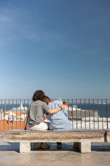 Tourist couple in love hugging while sitting on old city view background. High quality photo