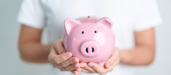 Money Saving for Future Plan, Retirement fund, Pension, Investment, Wealth Business and Financial concepts. hand holding and putting into piggy bank, Money Counting for World Savings day and Donate