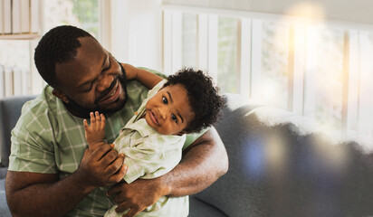Happy father hugging little son : African american father caring for his naughty and innocent cute...