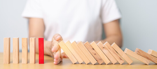 Hand stop falling wood domino blocks on table. Crisis, fall Business, Risk management, Economic...