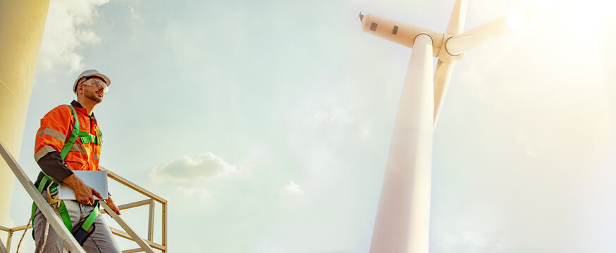 Caucasian male engineer technician worker holding wind turbine construction laptop exploring renewable energy industry development green energy sustainable environmentally friendly : Panoramic banner.