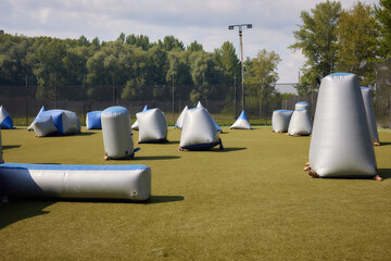 Paintball shooting range. Paintball territory in the forest. Iron barrels in the foreground with...