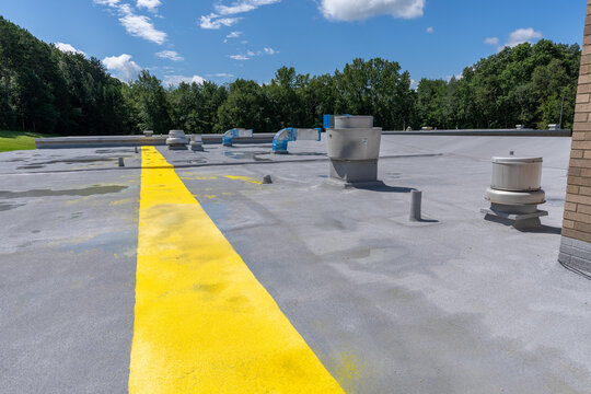 Painted safety yellow walkway on new spray foam roof for foot traffic.