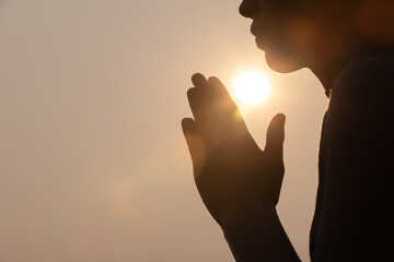 Silhouette of woman prayer position, Praying hands with faith in religion and belief in God on dark background. Power of hope or love and devotion. Namaste or Namaskar hands gesture. - obrazy, fototapety, plakaty