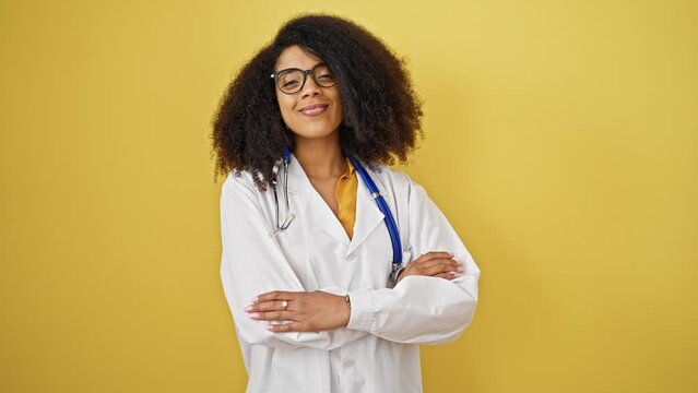 African american woman doctor smiling confident standing with arms crossed gesture over isolated yellow background
