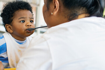 Mother raising an African-American Thai son feeds him simple and nutritious lunch : Portrait boy...