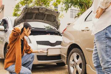Disappointed woman watching her car get damaged due to an accident caused by a male driver...