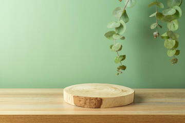 Empty wooden podium log on table over green leaves background. Cosmetic mock up for design and product display