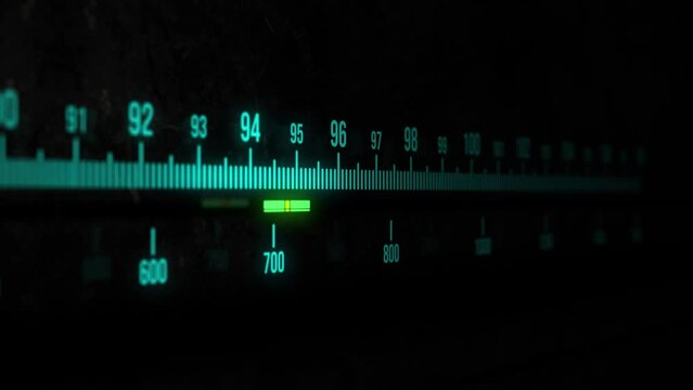 Moving sequence of a radio tuner display with glowing, light blue text and bars on a black background.