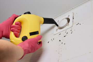 A man wipes dust from a ventilation grill technician cleaning air.
