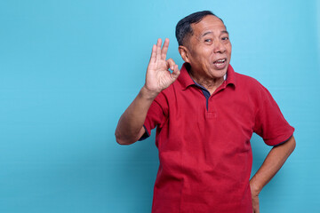 Fototapeta premium Elderly Asian man smiling and give OK hand sign