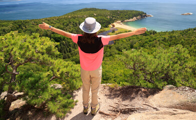 Teenager hiker standing on the rock and enjoying the landscape in Acadia National Park, Maine, USA