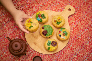 Close-up image of woman serving mooncakes on the table with tea