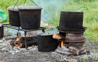 Hiking pot, Bowler in the bonfire. in cauldron at the stake. Traveling, tourism, picnic cooking,...