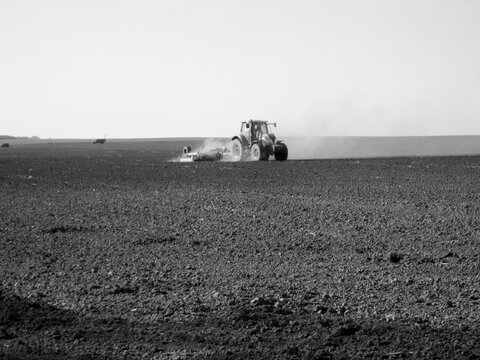 Plowed field by tractor in black soil on open countryside nature - Powered by Adobe