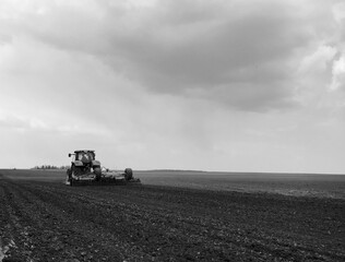 Plowed field by tractor in black soil on open countryside nature