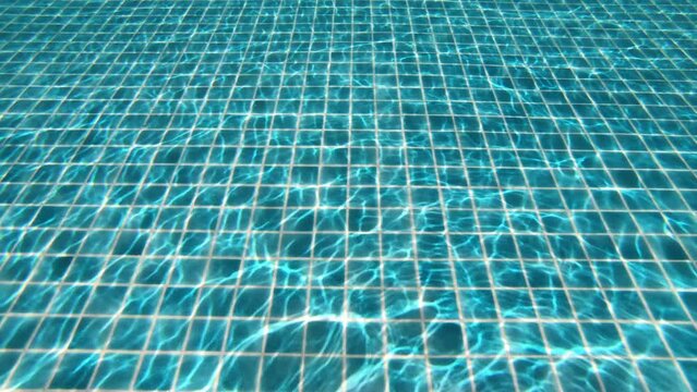 diving under of transparent blue water in swimming pool, close up 4K motion scene