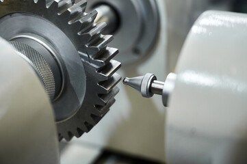 Grey cogwheel and oil nozzle in manufacturing workshop