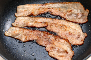 フライパンで焼いた薄切りベーコン