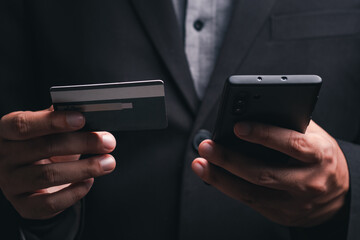 businessman is using a credit card with a smartphone for financial transactions. Online banking purchase product on internet in home office or online shopping. Convenience in the world of technology.