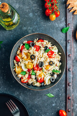 Mediterranean orzo salad with black olive, basil, red onion, tomato and cucumber.