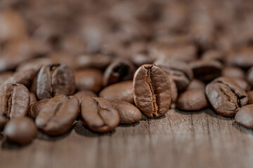 Roasted coffee beans on old wood table for background