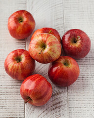 Ripe juicy red apples on a wooden white background. Harvesting.