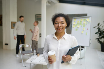 Portrait of female office worker holding digital tablet in hand