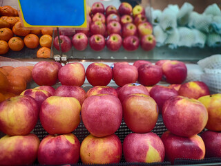 Red apples are arranged in the display shelf in a supermarket.