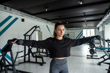 Fototapeta na wymiar fitness girl with a beautiful figure posing in the gym.