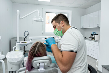 dentist conducts an examination for the patient who came for an appointment.