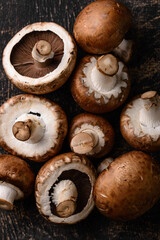 Raw champignon mushrooms on black background