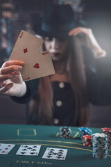 Woman before winning at poker  game with two aces in hand  at gaming table