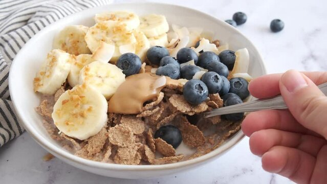 Multigrain wholewheat breakfast cereals with banana, coconut and blueberries. Vegan breakfast concept.
