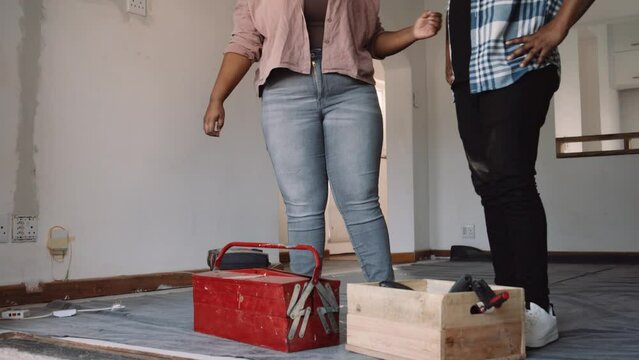 Black Couple Pacing Toolboxes on the Floor and Examining Their New Home While Hugging