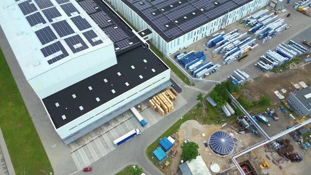 Aerial view of distribution center, drone photo of industrial logistics zone,new super modern logistics center full of modern technology and robotics,roof solar power plant for green energy production