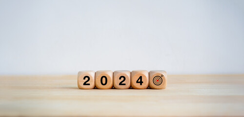 2024 Happy New year background. 2024 year number and target icon on wooden cube blocks arranged on...