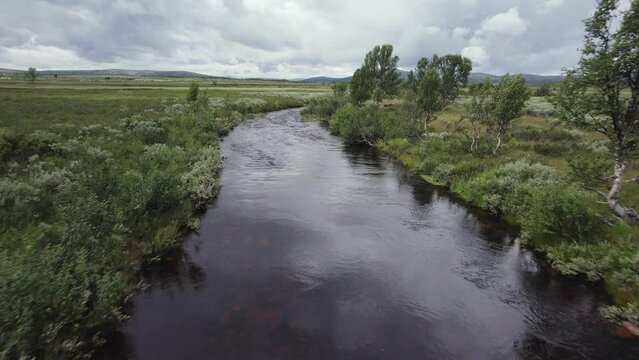 Aerial swoops over small bridge to follow natural river, Spekdalen NOR