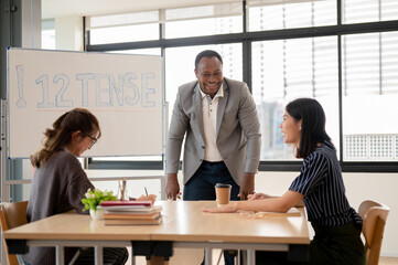 A cheerful African American male English teacher enjoying conversation with Asian students