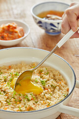 샤브샤브 볶음밥의 계란 노른자를 숟가락으로 터트리는 모습