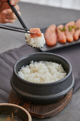 맛있게 지어진 흰쌀밥 한숟가락위에 명란젓을 한조각 얹어놓은 모습