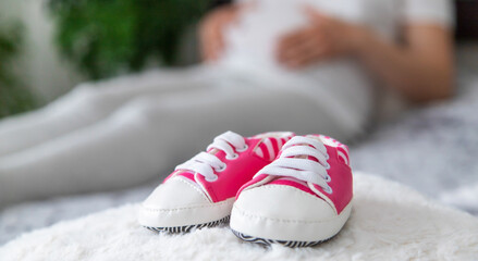 A pregnant woman collects baby things. Selective focus.