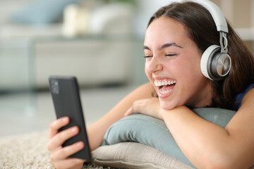 Happy woman watching videos laughing at home - 637236531