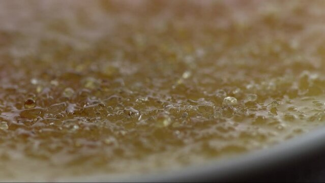 Extreme close-up flambe and burning sugar until brown from a sweet desert