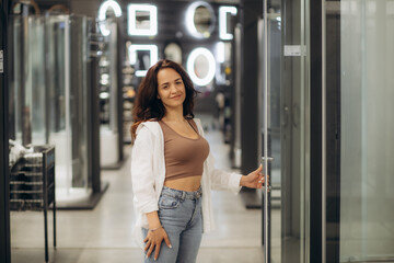Beautiful smiling woman looking for shower cabin in bathroom furniture store