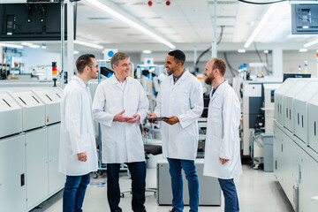 Technicians in lab coats having a meeting in electronics manufacture