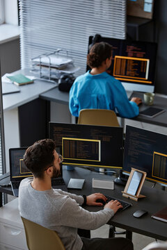 Computer programmers working on desktop PC at desk