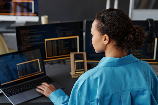 Young computer programmer working on laptop in office